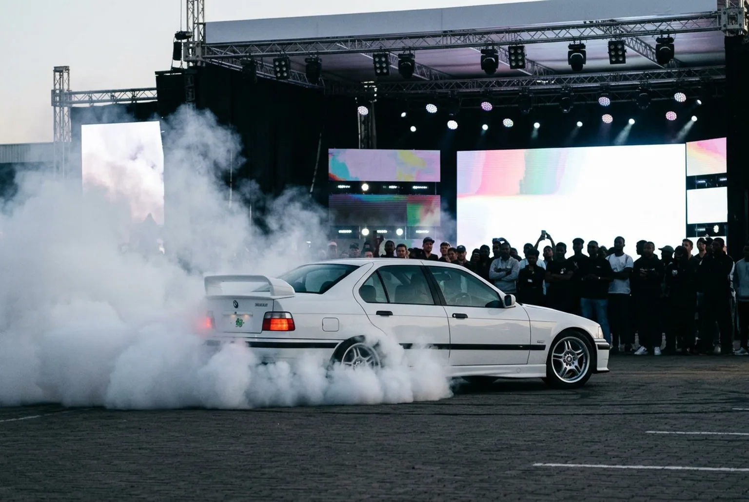 BMW E36 con ploteo de marca haciendo burnout en un evento de lanzamiento de producto en Buenos Aires