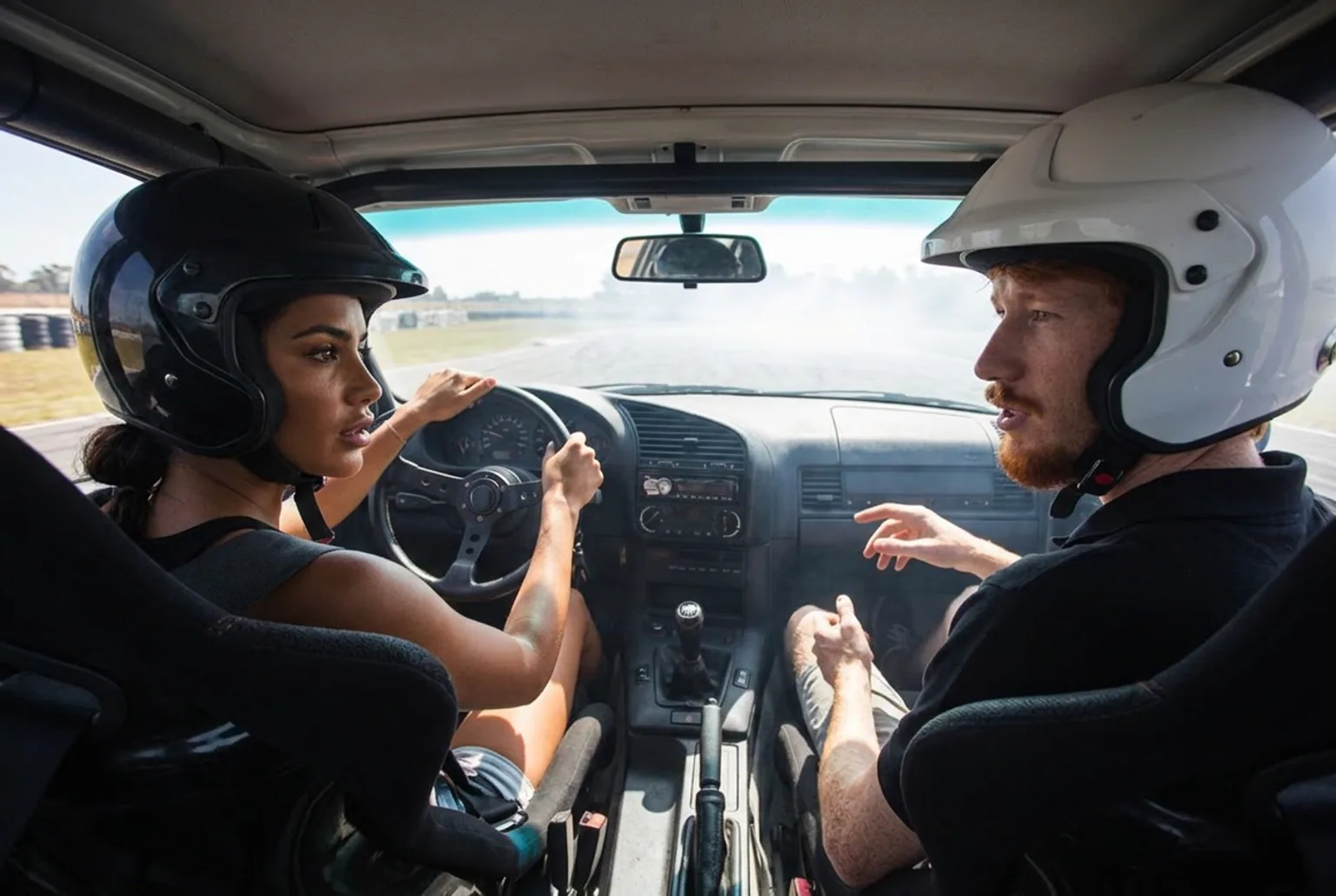 Instructor explicando la tecnica de drift a un alumno dentro del BMW E36 en una clase de adrenalina en pareja