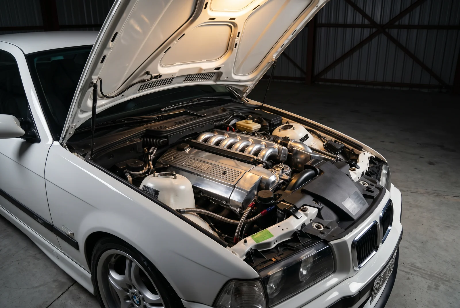 Motor BMW M52 de 2.8 litros 6 cilindros en linea del BMW E36 de la escuela de drift, capot abierto