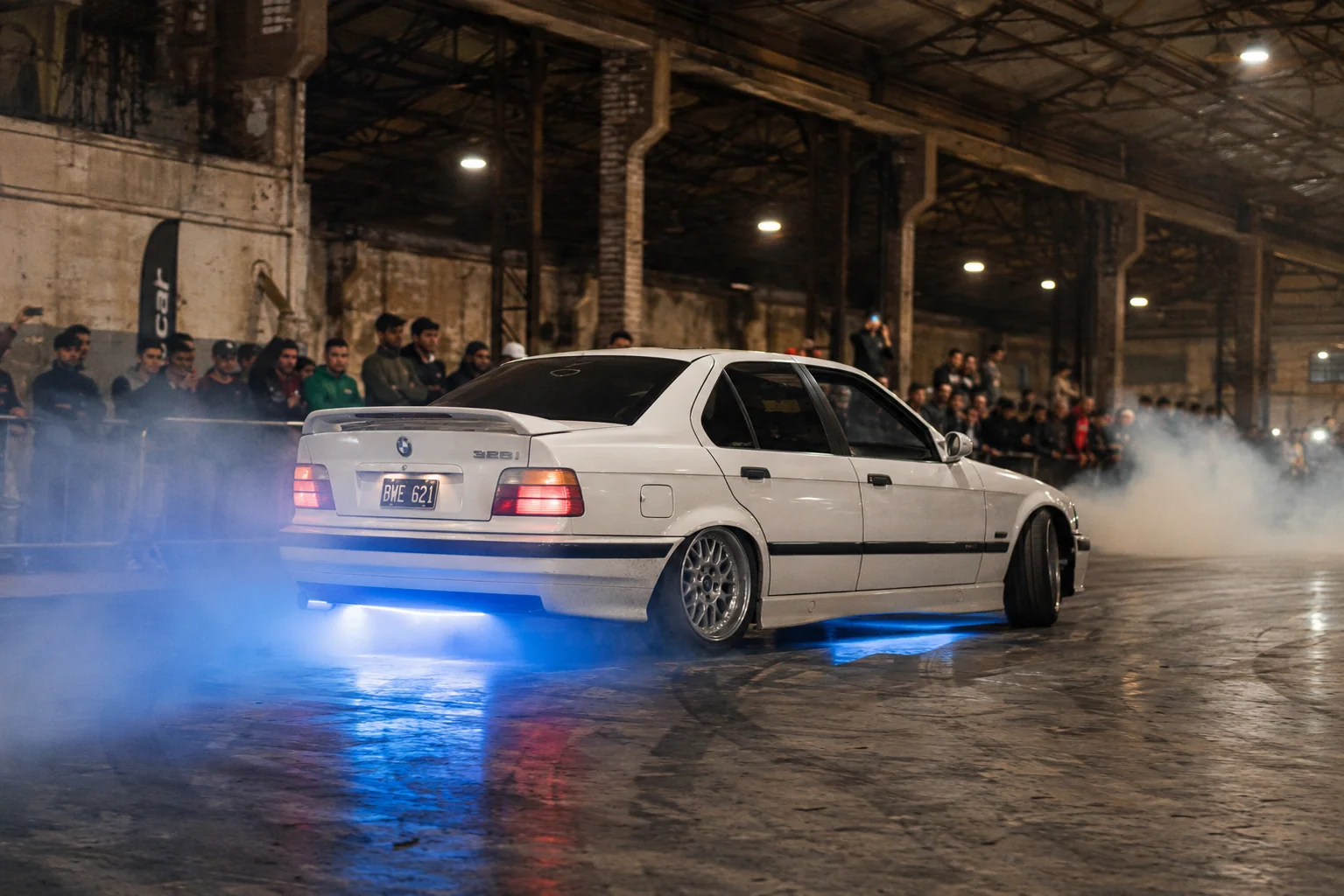Frente del BMW E36 con burnout y publico ejecutivo mirando — evento corporativo de drift real en Buenos Aires