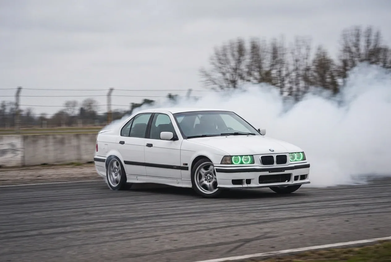 BMW E36 blanco derrapando en pista bajo cielo nublado, clase de drift en Buenos Aires