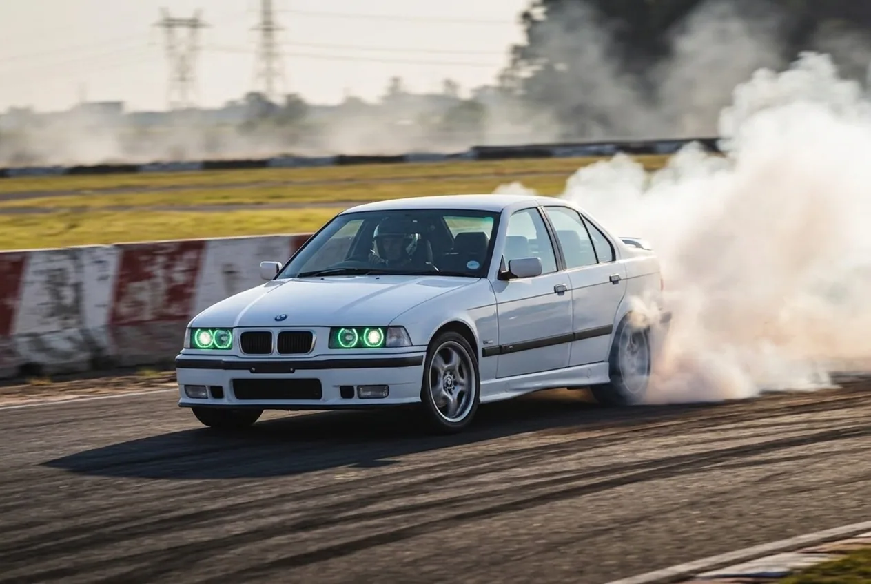 BMW E36 blanco encadenando un derrape por las eses al atardecer, manejo sostenido del Drift Experience
