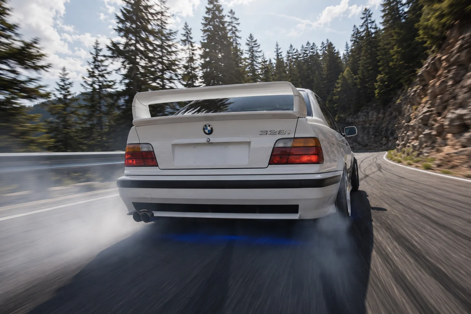 BMW E36 acelerando en ruta de montana con humo en el escape — la sensacion de drift a los 40