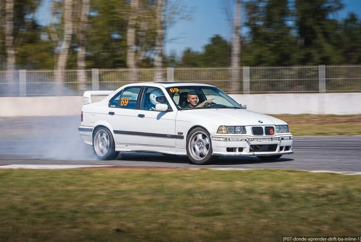 Aluno iniciante recebendo instrucao ao volante de um BMW E36 numa pista fechada perto de Buenos Aires