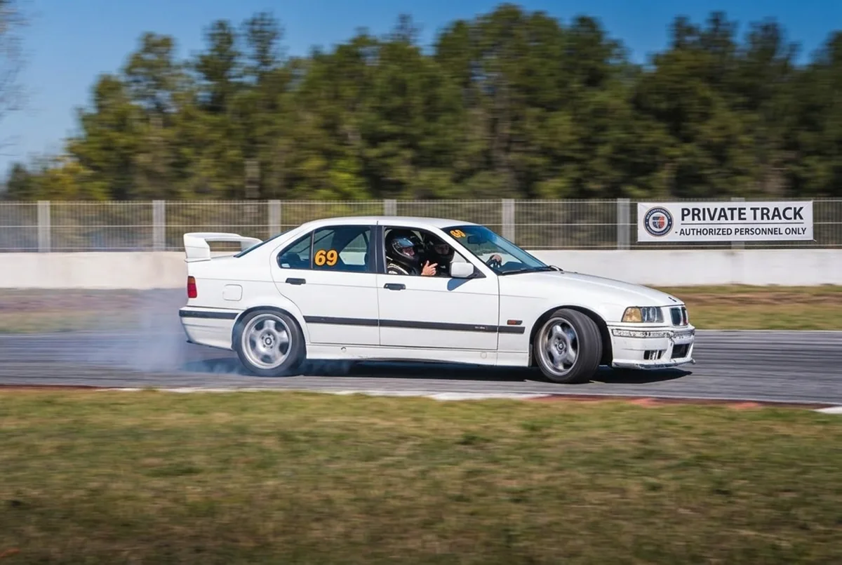 BMW E36 blanco derrapando en pista cerrada con instructor a 40-50 minutos de CABA — clase de drift cerca de Buenos Aires