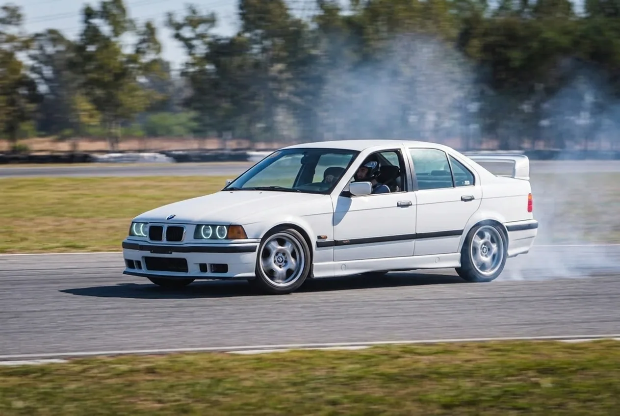 BMW E36 blanco en pleno drift sobre asfalto, listo para reservar una clase en Buenos Aires