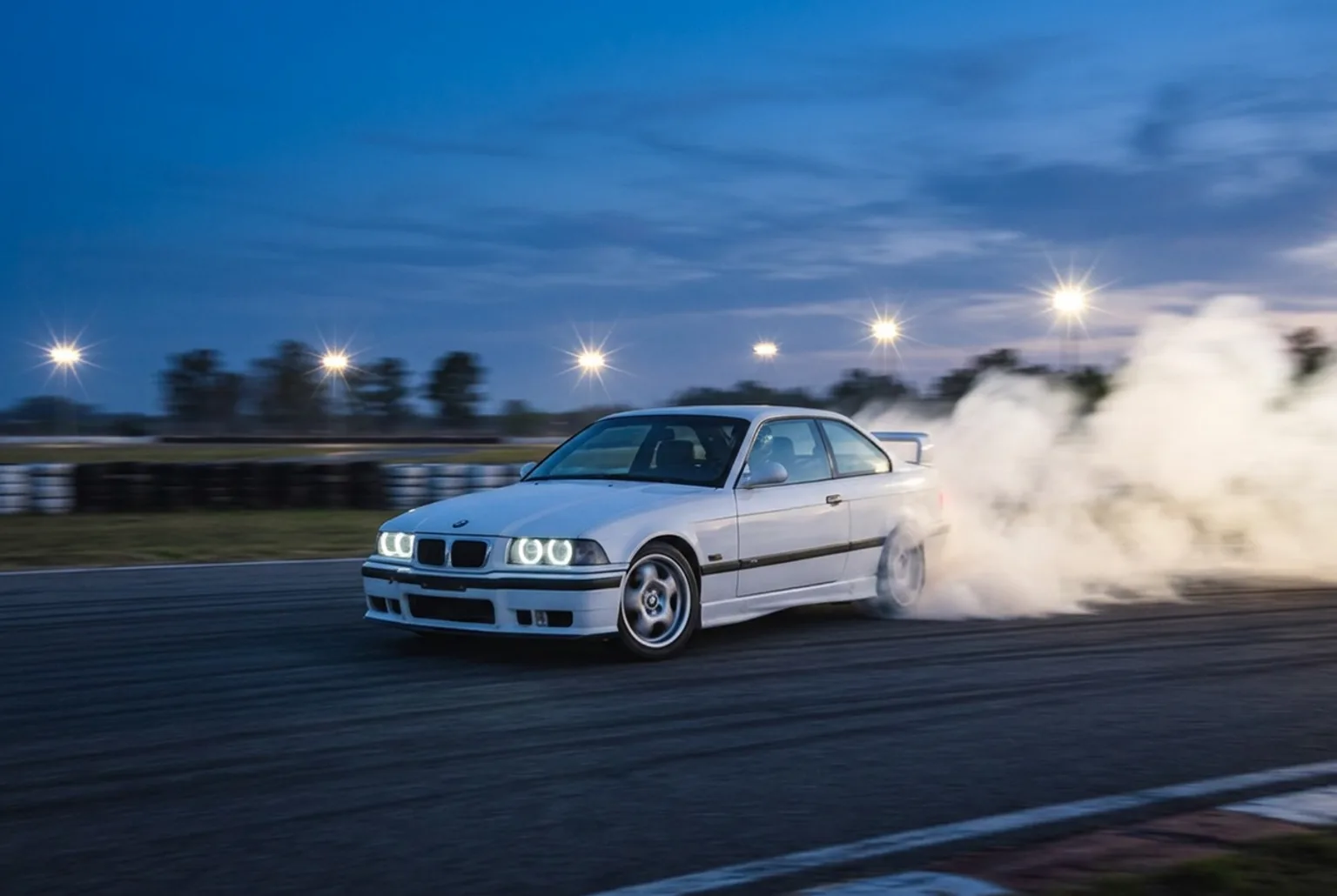 BMW E36 blanco en pleno derrape con humo de neumaticos, experiencia de drift para festejar una graduacion en Buenos Aires