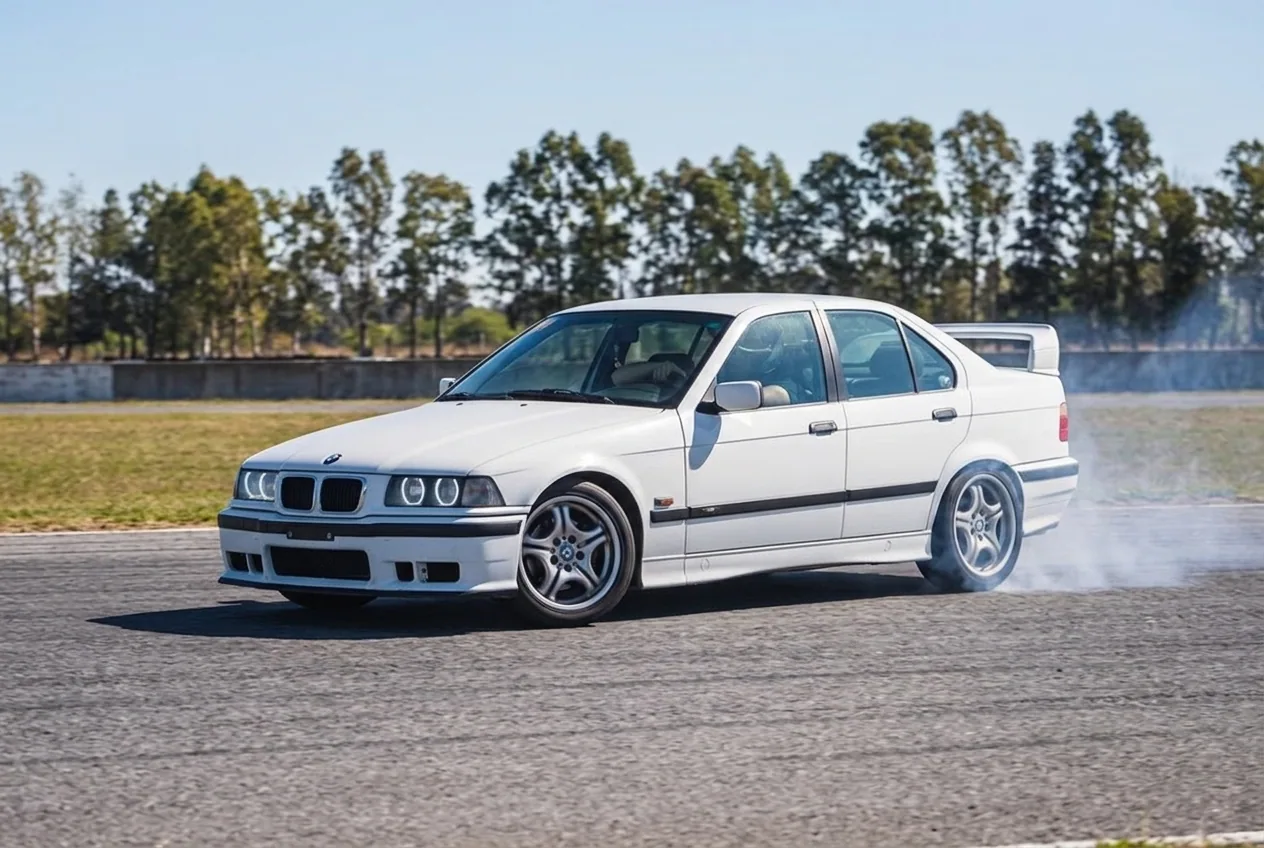 BMW E36 blanco de costado en pleno drift mostrando contravolante, fundamentos de la tecnica de drift