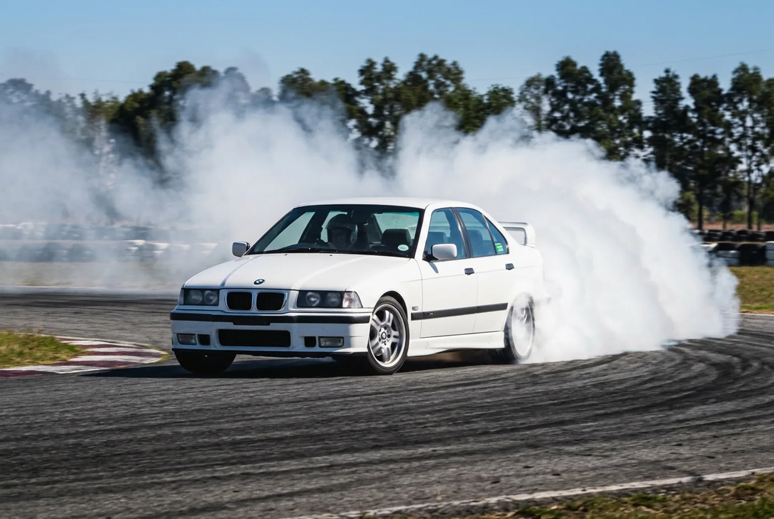 BMW E36 derrapando con humo blanco en pista cerrada de Buenos Aires, plano ideal para grabar contenido