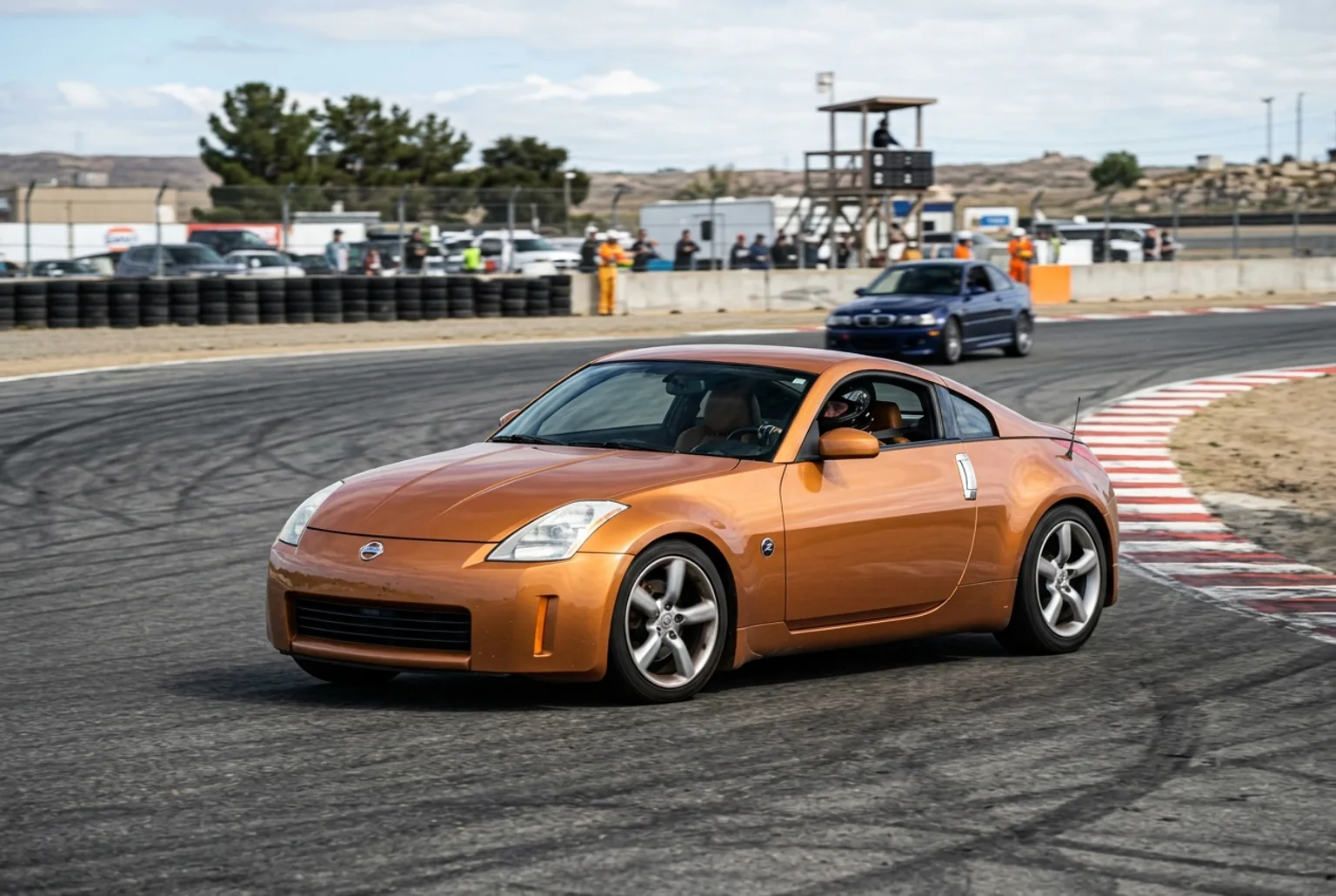 Nissan 350Z color bronce en la pista de un autódromo, cupé deportivo de tracción trasera